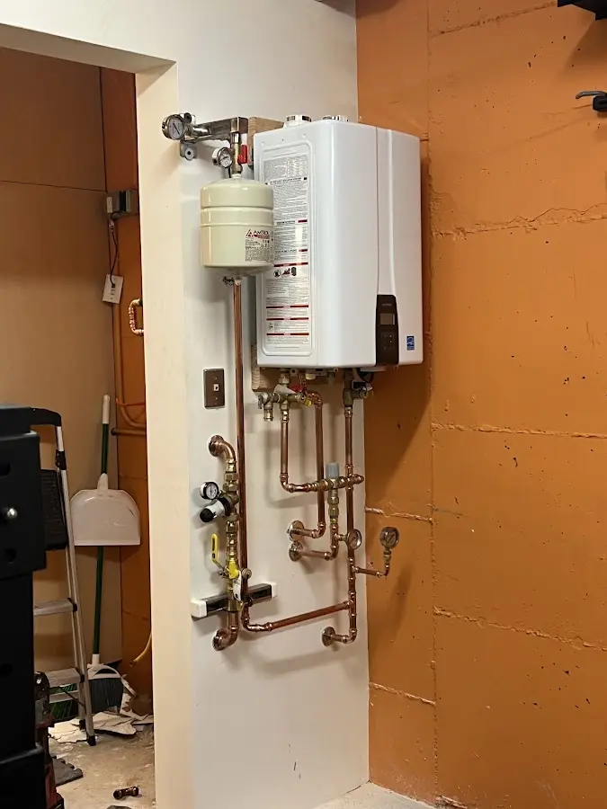 Plumbing technician inspecting water heater connections in North Tustin